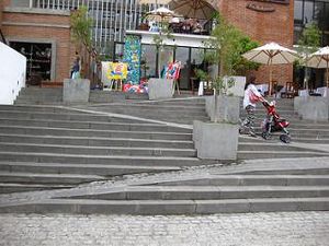 Photo by Beau Lebens (https://www.flickr.com/photos/borkazoid/) A wide staircase with a ramp blended into its lower section outside a building
